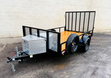 A cart equipped with a trailer tool box, positioned outdoors on a paved surface.